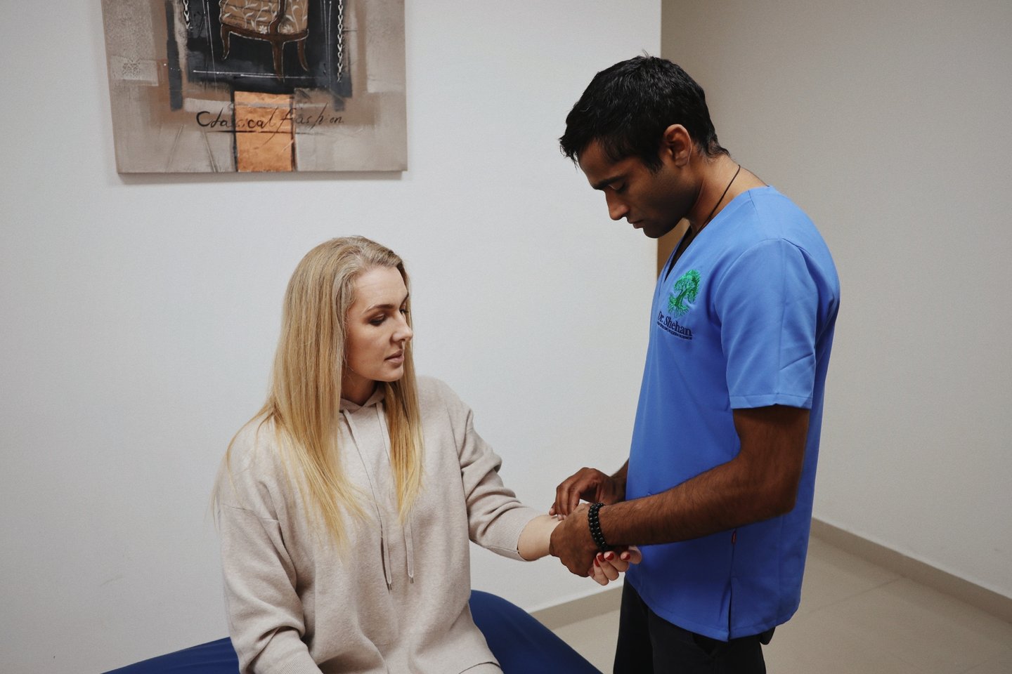 Dr Shehan taking a patient's wrist pulse during an integrative assessment