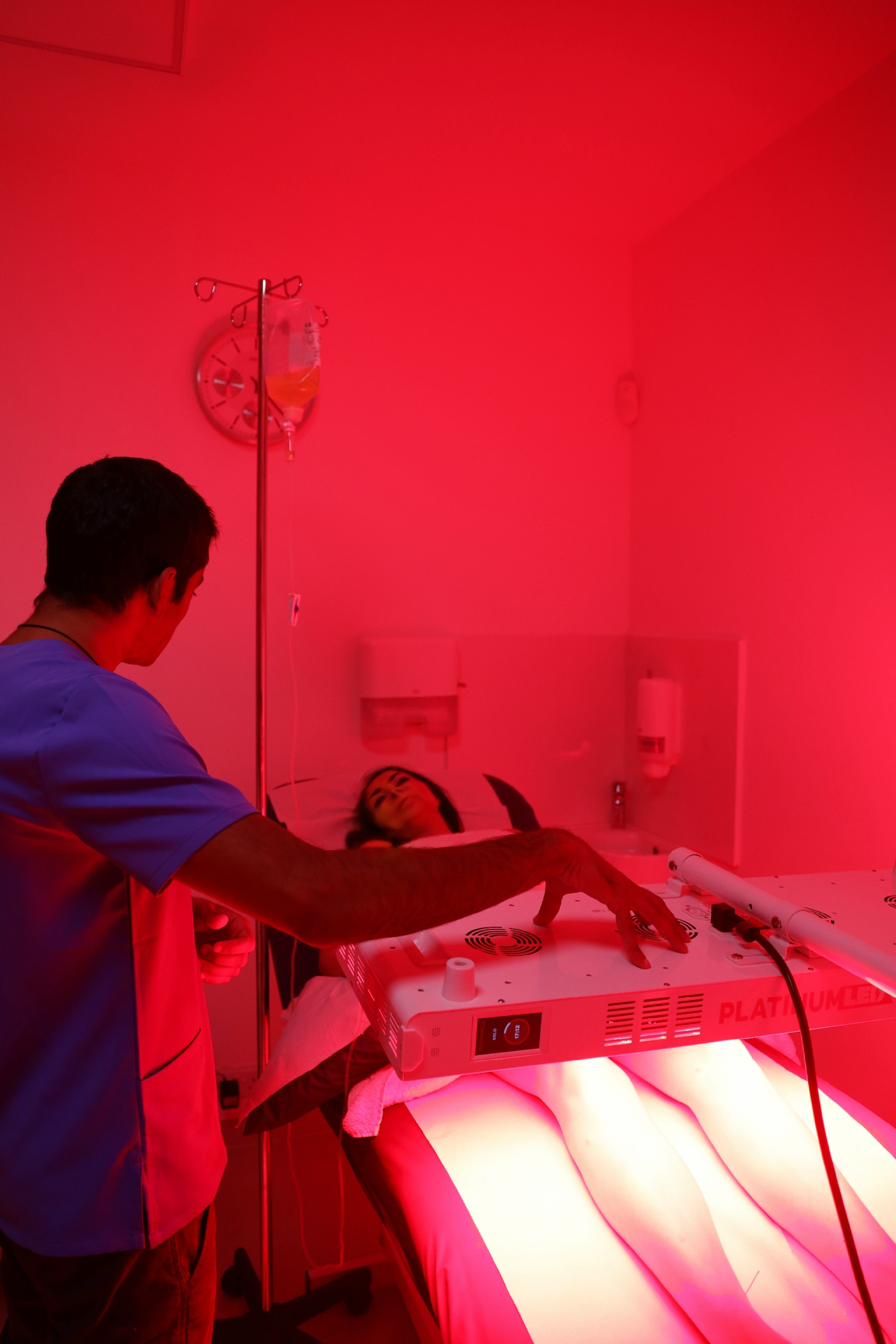 Patient receiving red light therapy with IV support during an Integrative Reset treatment session