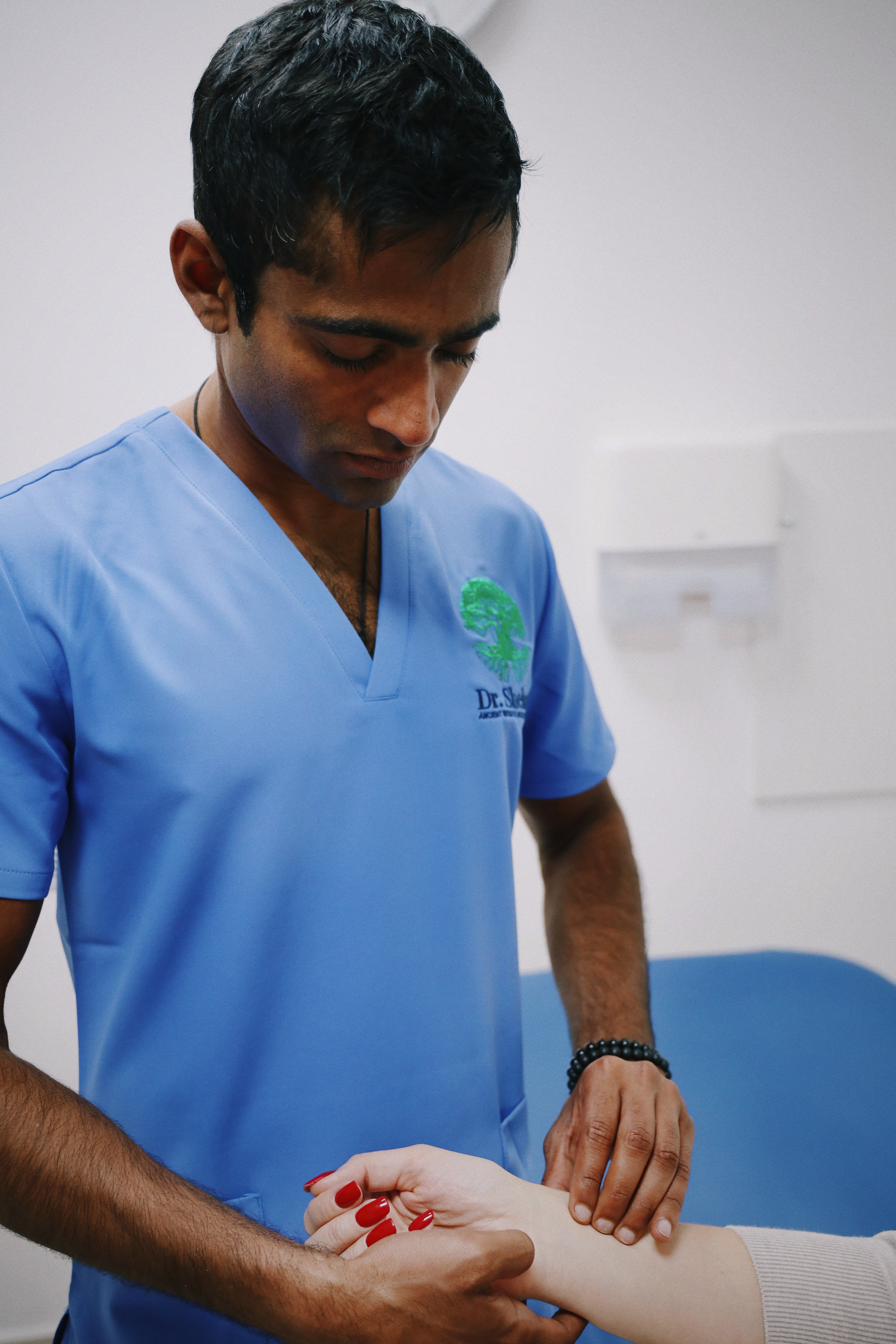 Dr Shehan performing pulse diagnosis during an integrative clinical assessment