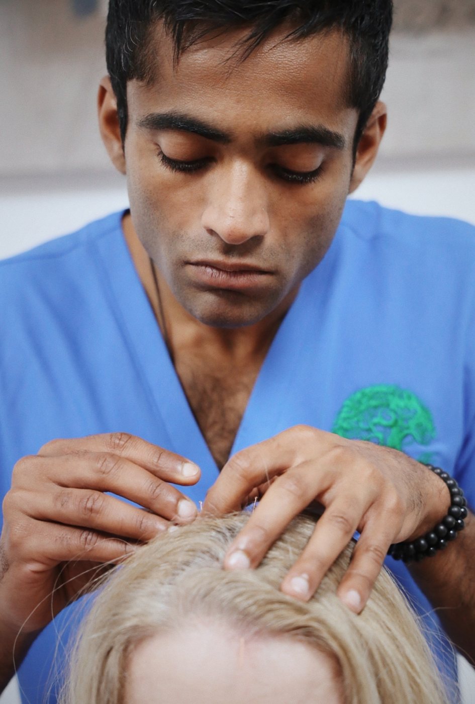 Dr Shehan performing scalp acupuncture with deep concentration